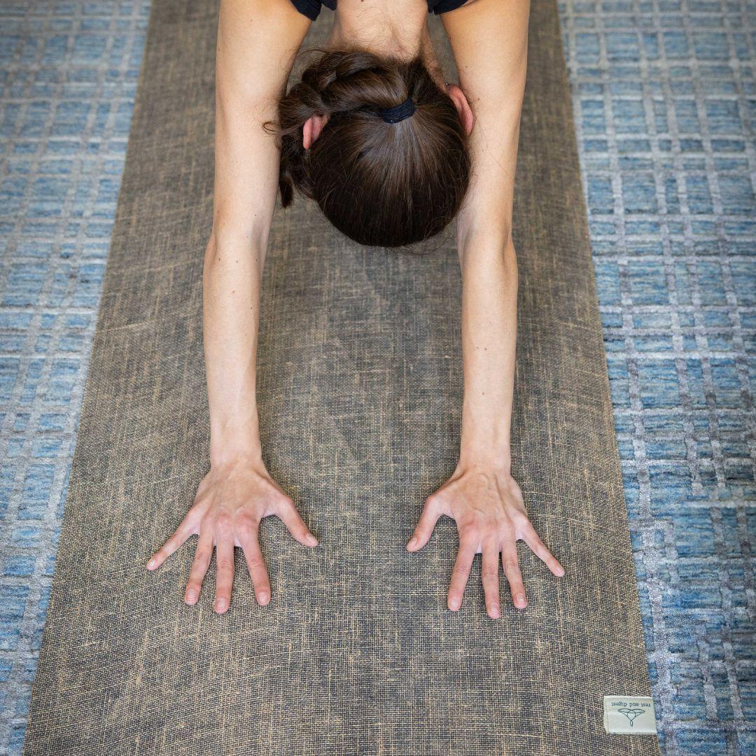 woman stretching out doing yoga on her mat